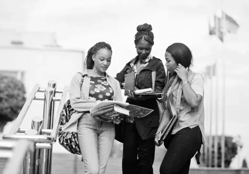 three-african-students-female-posed-with-backpacks-school-items-yard-university